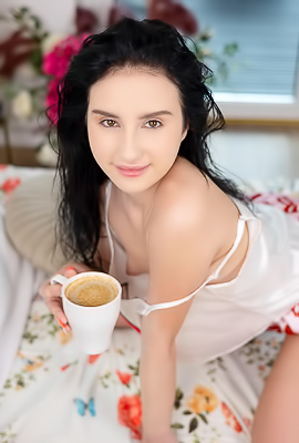 >Sasha Jane teases languidly on the silk sheets, revealing her shaved pussy beneath the short shorts